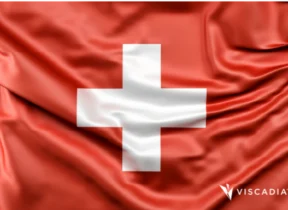 A red flag with a white cross in the center, symbolizing Switzerland; the Viscadia logo appears in the bottom right corner.