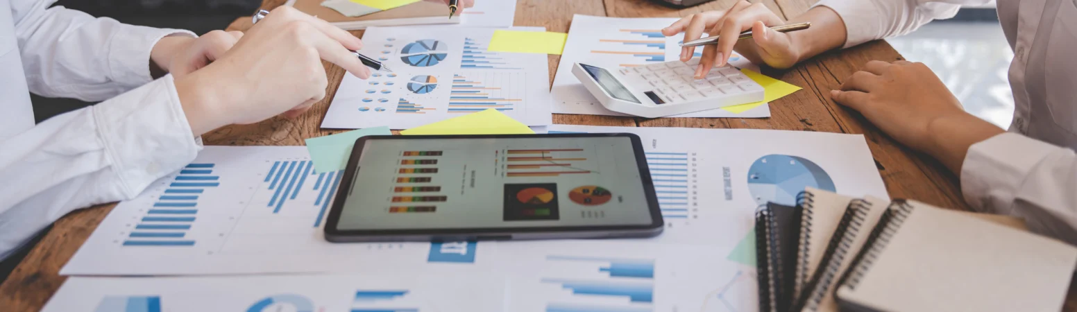 Business team analyzing market data and financial reports on a conference table.