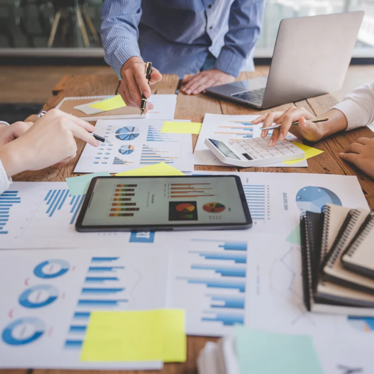 Business team analyzing market data and financial reports on a conference table.